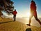 Two athletes couple run together in spring lake landscape