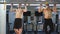 Two athletes doing pull-up on horizontal bar in the gym