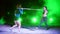 Two athletic girls in pair doing various strength exercises with a barbell, lunges, squats, At night, in light smoke