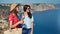 Two attractive casual travel girl admiring beautiful seascape from top of mountain medium shot