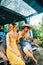 Two attractive cheerful women drinking lemonade near van, enjoying summer vibes in road trip