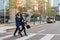 Two attractive confident hispanic businessmen in suits walking outdoors at the city streets. Two businessmen walking and