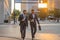 Two attractive confident hispanic businessmen in suits walking outdoors at the city streets. Two businessmen walking and