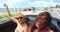 Two attractive girls driving in convertible with top down and enjoying the wind