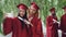 Two attractive girls fellow students are taking selfie on graduation day holding diplomas, young women are smiling