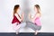 Two attractive sports girls practice yoga in a fitness class. Young women