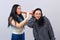 Two attractive teenager girls having fun with wooden flute isolated on light background