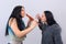 Two attractive teenager girls having fun with wooden flute isolated on light background