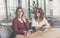 Two attractive young brunette women sit in cafe at table and drink coffee. Meeting friends at restaurant.