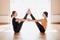 Two attractive young women balancing and practicing yoga in a light studio. Well being, wellness concept. One of the woman is plus
