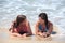 Two attractive young women lying on a sunny beach near the water