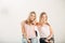 Two attrative sisters twins pointing over white background