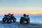 Two ATVs at sunset over the frozen north sea