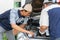 Two Auto repairman checks the engine and cooling system before traveling on a long holiday. Concept of Car care and maintenance