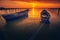 Two backlit fishing boats with the sun in the background at sunrise or sunset