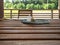 Two badminton rackets and shuttlecock lie on a wooden table on the terrace of a country house. Lush green foliage in the