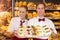 Two bakers holding tray with sandwiches in baker\'s shop