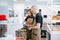 Two bakers, young man and woman working in the kitchen, keen on their task