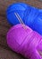 Two balloons of yarn with knitting needles