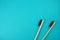 Two bamboo toothbrushes on turquoise background. Love, healthcare, zero waste, treatment concept.
