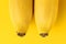 Two bananas as a symbol of the female breast boobs. Erotic fruits on a yellow background