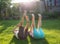 Two barefoot children lie on the grass with their feet up