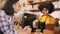 Two baristas partners talk and cheerful smile at the counter bar of coffee shop.