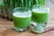 Two barley grass shots on a wooden background