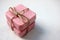 Two bars of pink handmade soap tied with twine on the white wooden background.