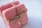 Two bars of pink handmade soap tied with twine on the white wooden background.