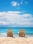 Two beach chairs on sea shore near water under blue clear sky. Stunning seascape background, summer vacation concept