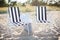 Two beach lounges with beach bag and white hat