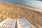 Two beachchairs on the sand near sea, closeup