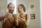 Two beaming potters standing near the decorated wall in workroom