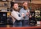 Two bearded hipster coffee shop owners at the counter.