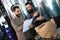 Two bearded men check quality of the malt. Workers of brewery conduct product analysis.