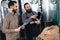 Two bearded men check quality of the malt. Workers of brewery conduct product analysis.