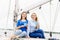 Two beautiful, attractive young girls drinking coffee on a yacht