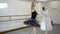 Two beautiful ballerinas rehearse dance in ballet studio.