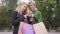 Two beautiful blond girlfriends standing on the street with shopping bags looking at cellphone. Two fashion women