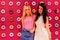 Two beautiful blonde and brunette girls closeup on the pink donut background