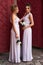Two beautiful bridesmaids girls blonde and brunette ladies wearing elegant full length lavender violet tulle one