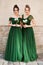 Two beautiful bridesmaids girls blonde and brunette ladies wearing elegant full length off-the-shoulder green chiffon