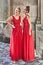 Two beautiful bridesmaids girls blonde and brunette ladies wearing elegant full length red chiffon bridesmaid dress with