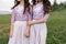 Two beautiful bridesmaids girls brunette ladies wearing full length lavender tulle one shoulder bridesmaid dress