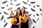 Two beautiful brunette women in black dresses have fun with jack-o-lanterns on a white background with bats and spiders