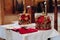 Two beautiful crowns with gold and red cloth stand on a table in the church before the baptism of the baby