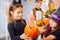 Two beautiful dark-haired girls wearing Halloween costumes eating scary sweets