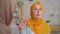 Two beautiful deaf young Muslim women in hijabs Talking With Sign Language in the living room close up of the house