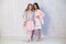 Two beautiful fashionable girl girlfriends in white pink dresses